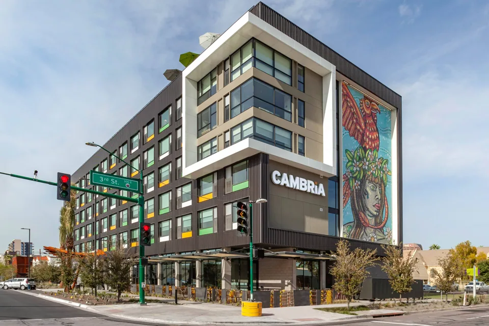 Cambria Hotel corner exterior with its colorful mural and entrance on Third Street