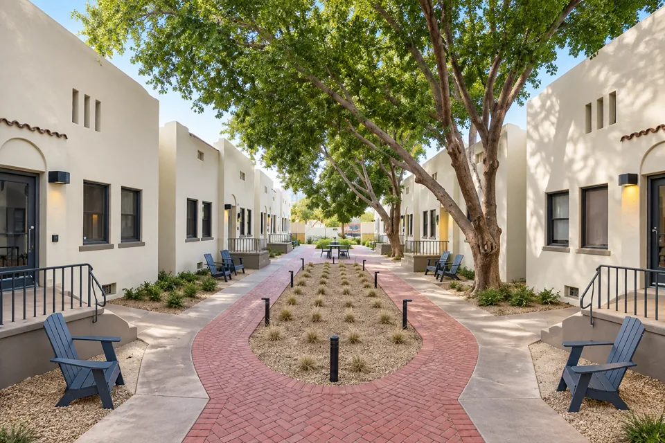 Arcada courtyard framed by historic white buildings and mature trees