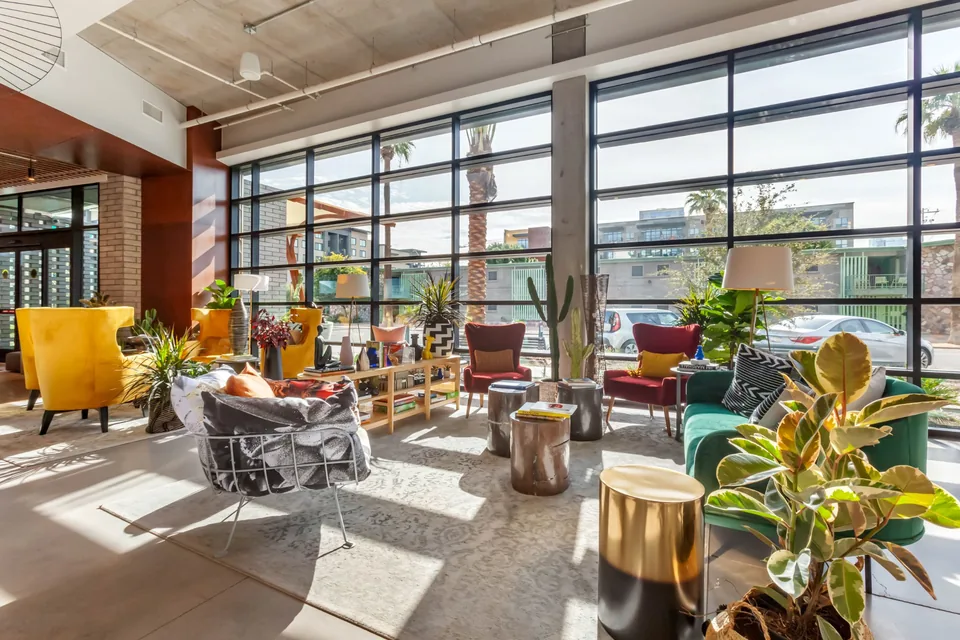 Cambria Hotel lobby with colorful seating, plants and large street-facing windows